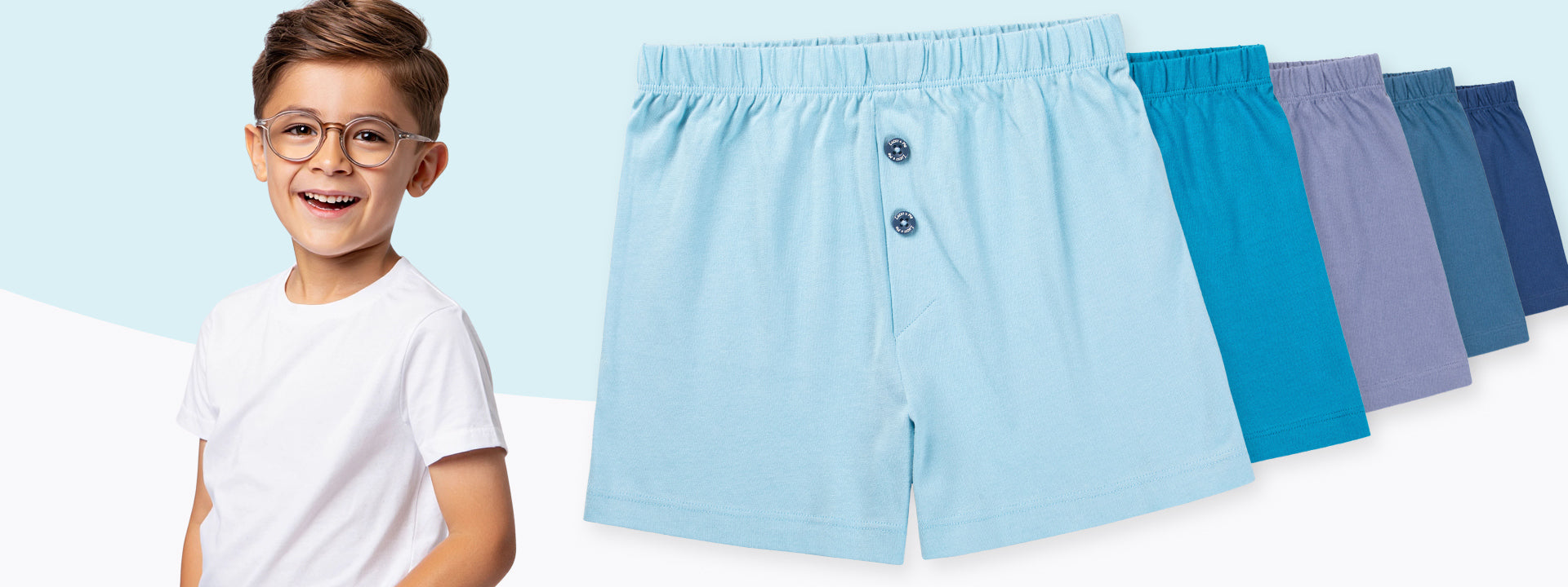 Boy wearing light blue boxer shorts with additional colors displayed on a light blue background