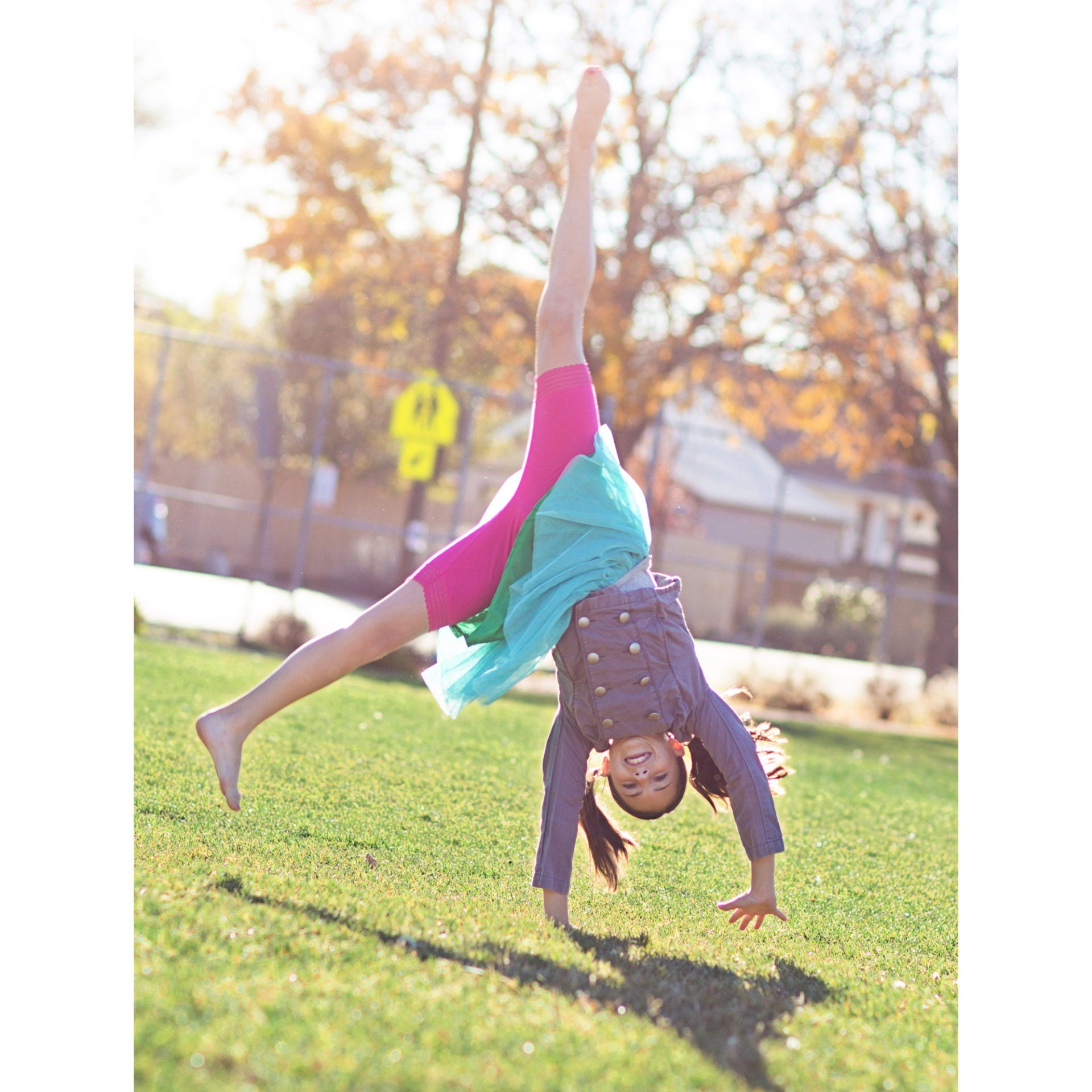 Girl doing cartwheel and wearing pink bike shorts under skirt