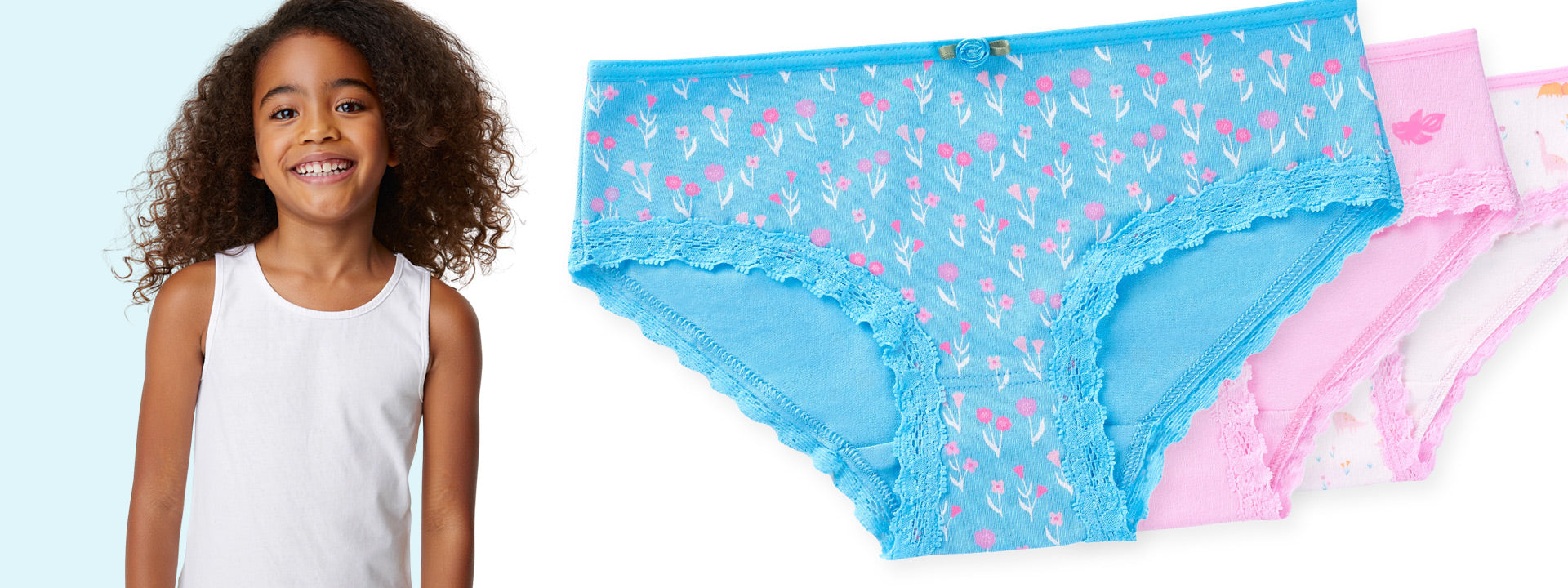 Child wearing a white sleeveless top next to a pair of blue underwear with pink floral pattern on a light blue background