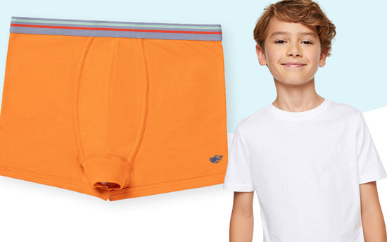 Youth boy wearing orange Jameson performance cotton boxer briefs with a white Logan t-shirt. 